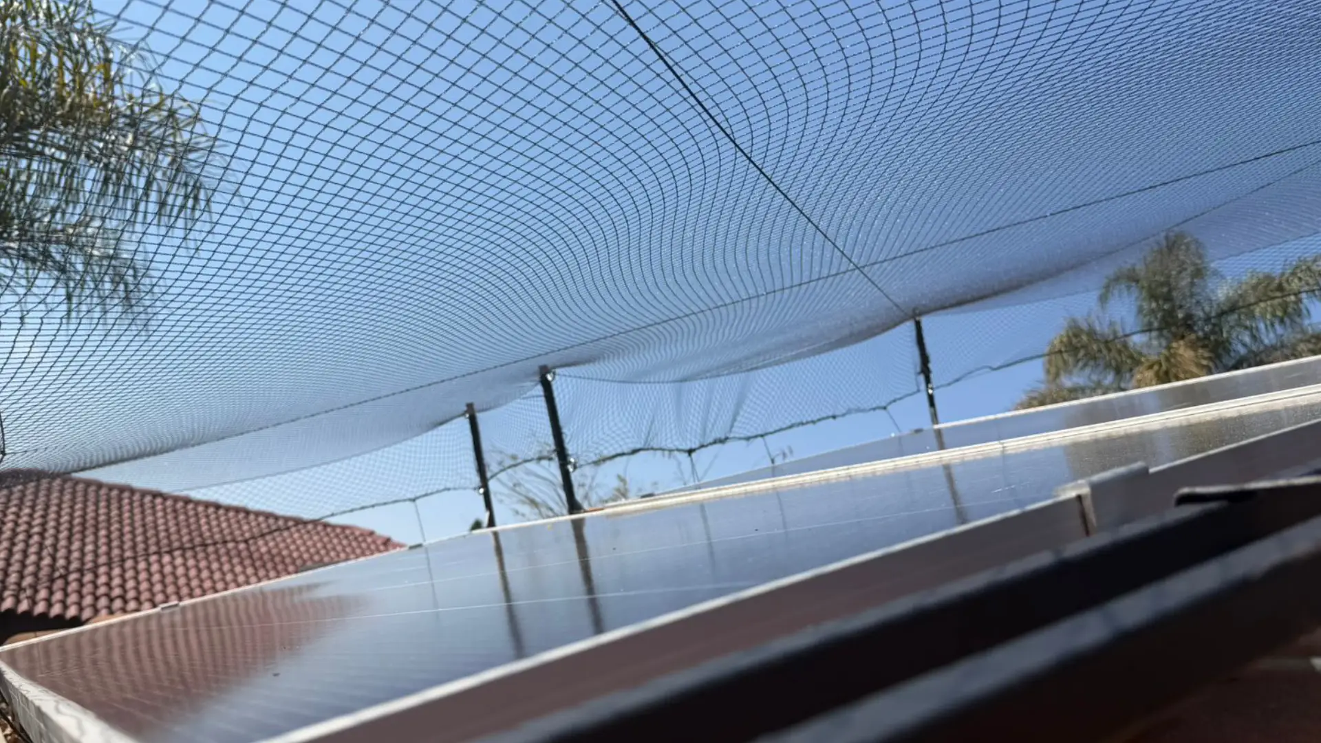 Solar panel netting Pretoria – protective golf ball netting installed over rooftop solar panels on a golf estate home by PFB Energy Group